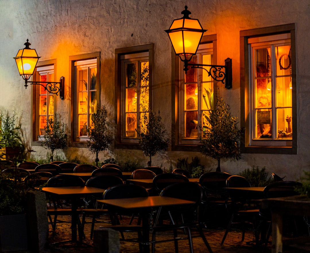 A row of tables sitting outside of a restaurant at night